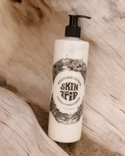 Lotion bottle labeled 'Skin Trip' by Mountain Ocean on a wooden surface