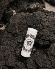 Skincare bottle labeled 'Skin Tip' on a textured black surface