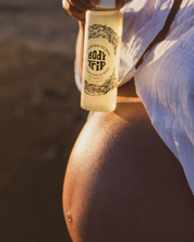 Person holding a bottle labeled 'Body Trip' against a blurred background