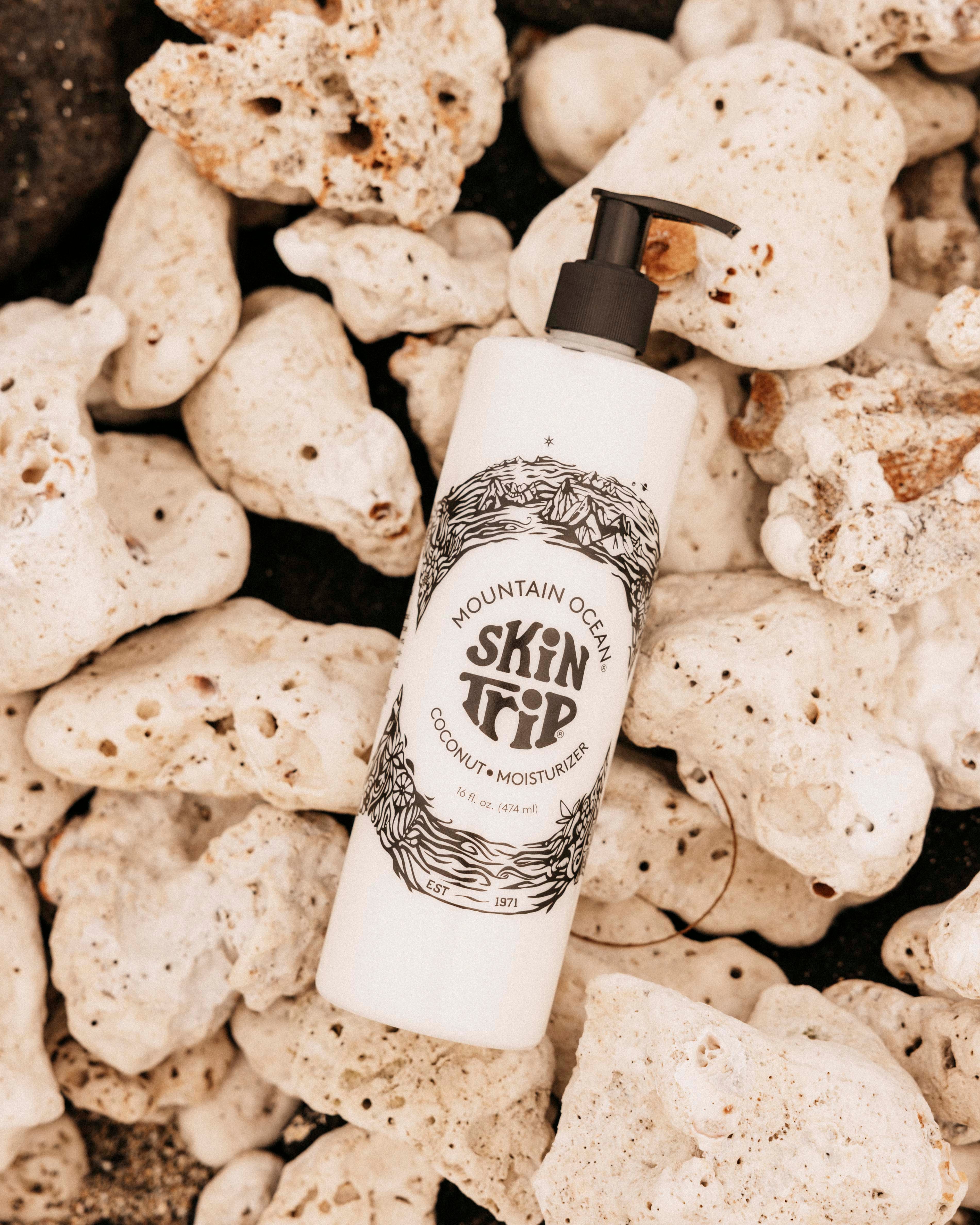 Skincare product bottle labeled 'Skin Deep' on a rocky surface